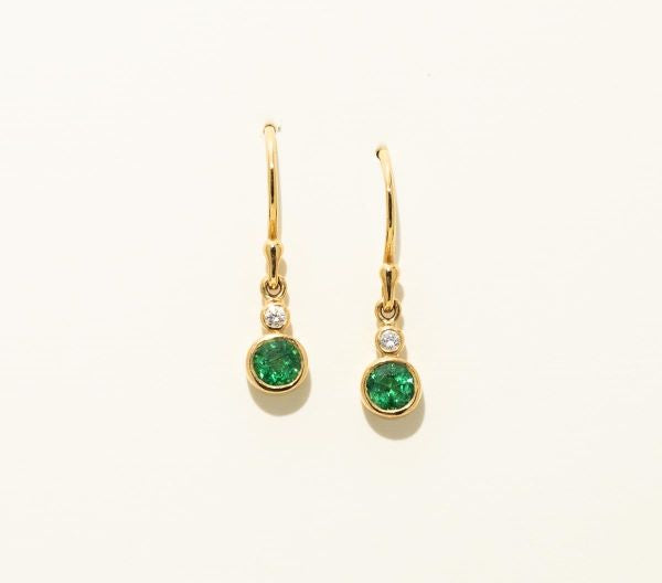 Gold earrings with green gemstones on a white background