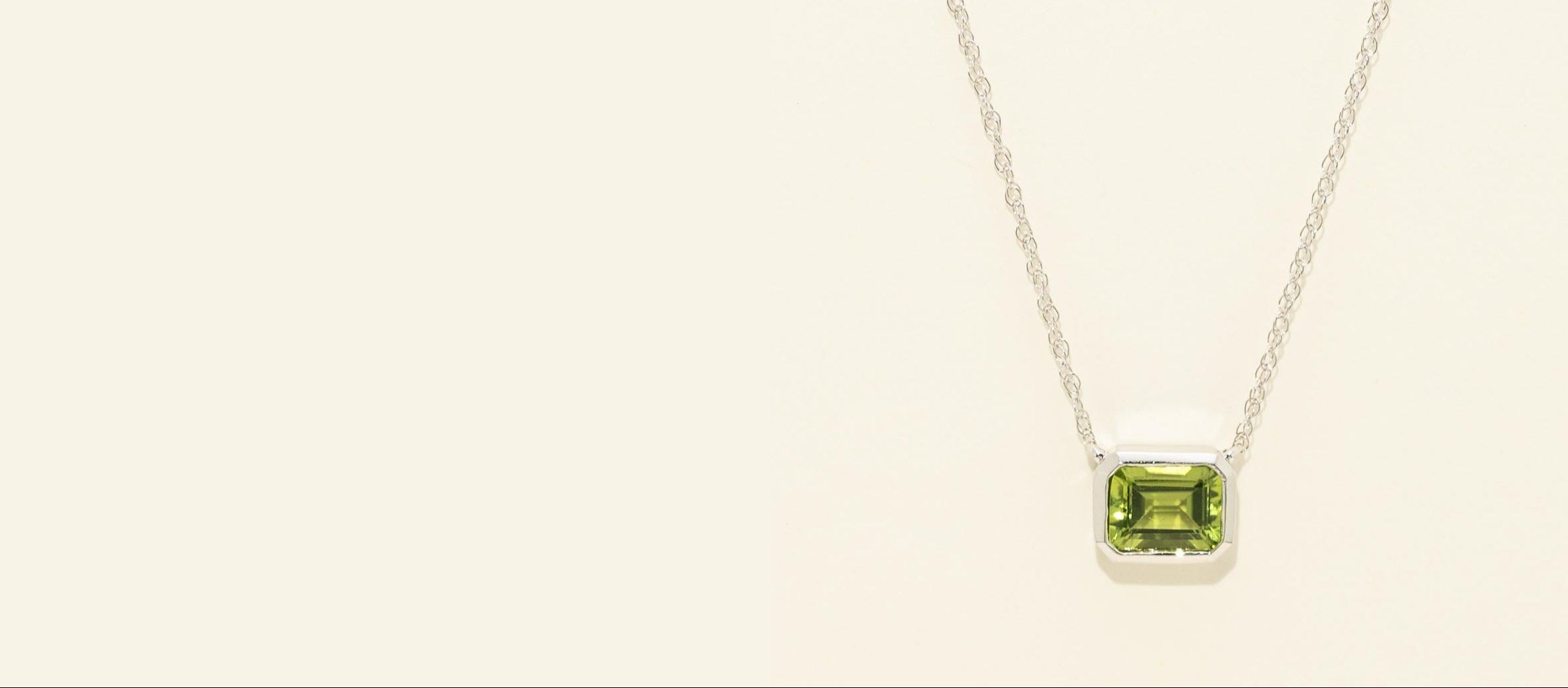 Necklace with a green gemstone pendant on a light beige background
