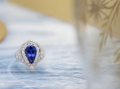 Ring with a blue gemstone on a blurred background