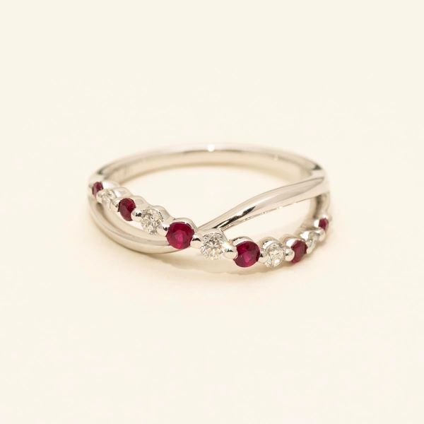 Silver ring with red gemstones on a beige background
