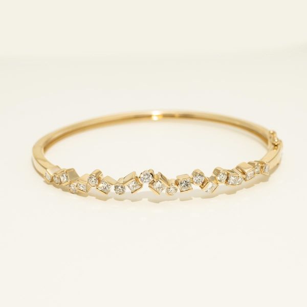 yellow metal bangle bracelet with clear diamonds in a variety of shapes