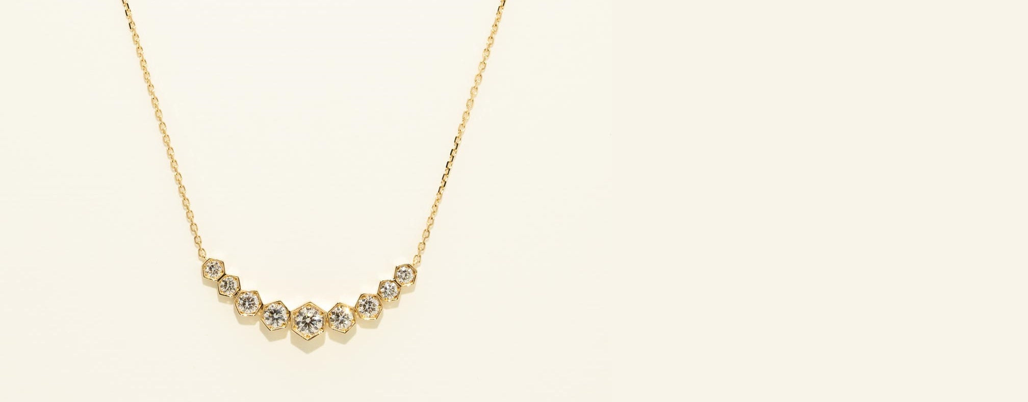 Gold necklace with small beads on a light beige background
