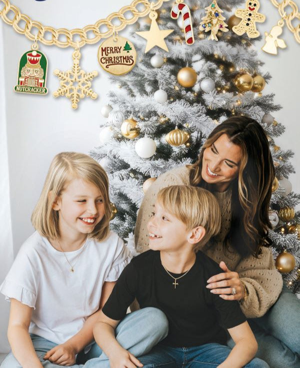 Family sitting in front of a Christmas tree with Rembrandt Charms jewelry displayed.