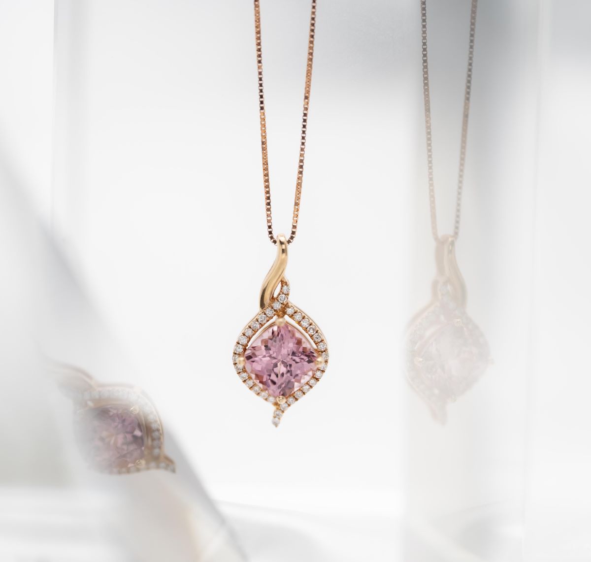 Pink gemstone necklace with rose gold chain on a white background