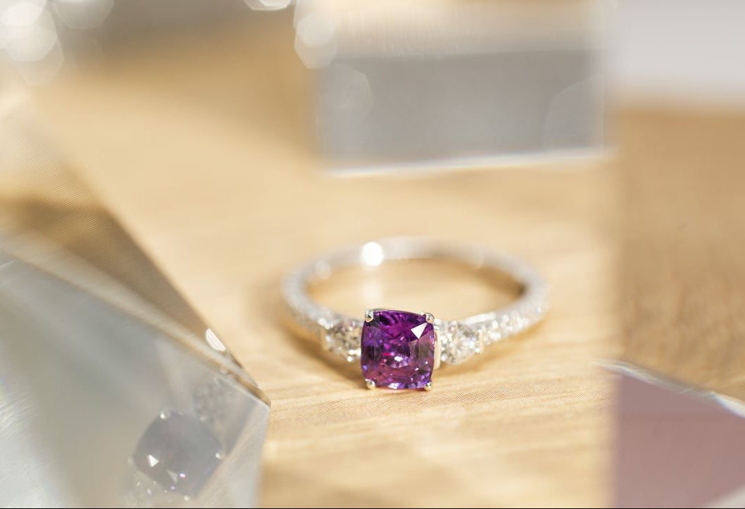 Ring with a purple gemstone on a wooden surface