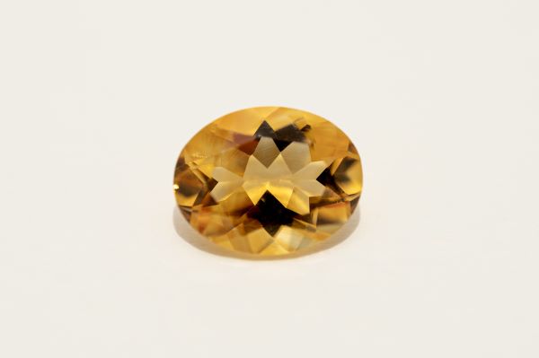 Yellow gemstone on a light gray background