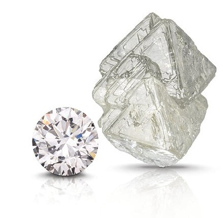 Round cut diamond next to a rough diamond on a white background