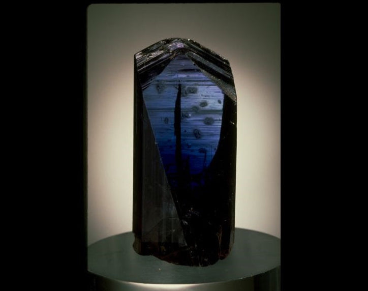 Crystal-like object with a reflective surface on a dark background