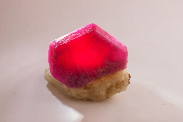 Crystal-like object with a red interior on a beige background
