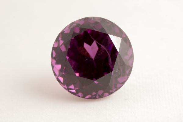 Round purple gemstone on a white background